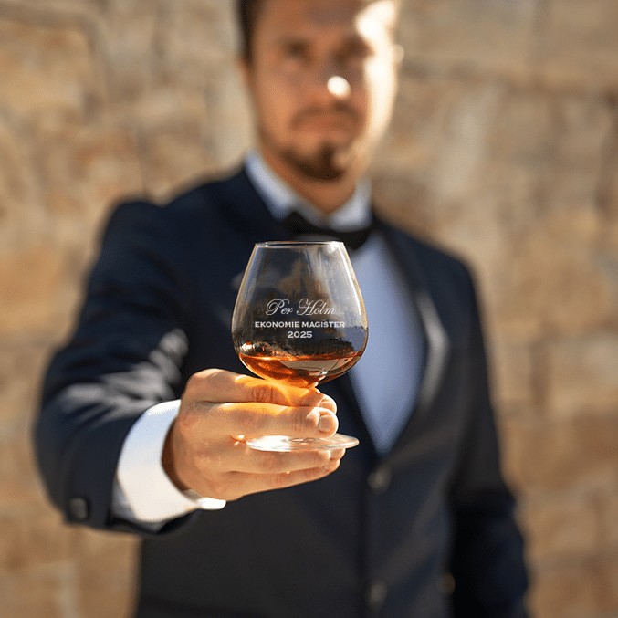 Stämningsfull bild på konjaksglas med gravyr - ett utmärkt exempel på examenspresent